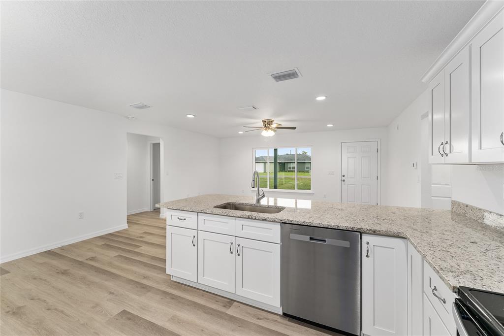 13119 Northeast 7th Loop Silver Springs, FL 34488 - Photo 23 of 51 a kitchen with granite countertop cabinets stainless steel appliances a sink and dishwasher