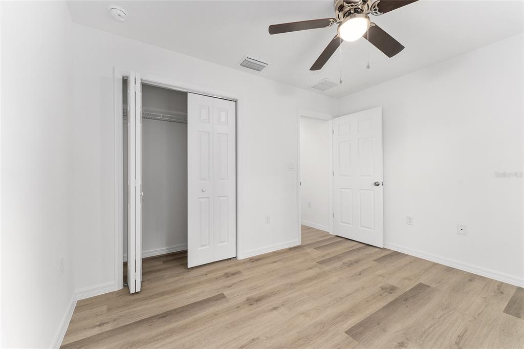13119 Northeast 7th Loop Silver Springs, FL 34488 - Photo 27 of 51 an empty room with wooden floor closet and fan