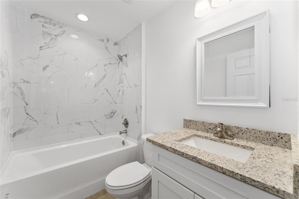 13119 Northeast 7th Loop Silver Springs, FL 34488 - Photo 29 of 51 a bathroom with a granite countertop sink a toilet and bathtub