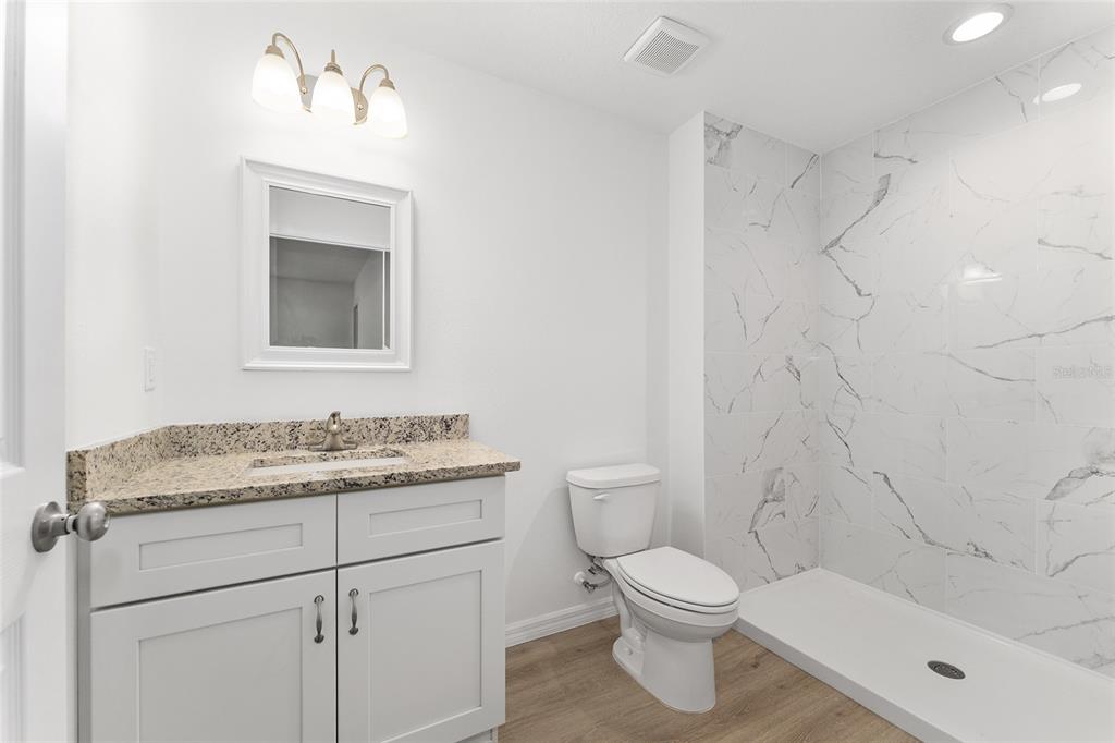 13119 Northeast 7th Loop Silver Springs, FL 34488 - Photo 38 of 51 a bathroom with a granite countertop toilet a sink and a bathtub