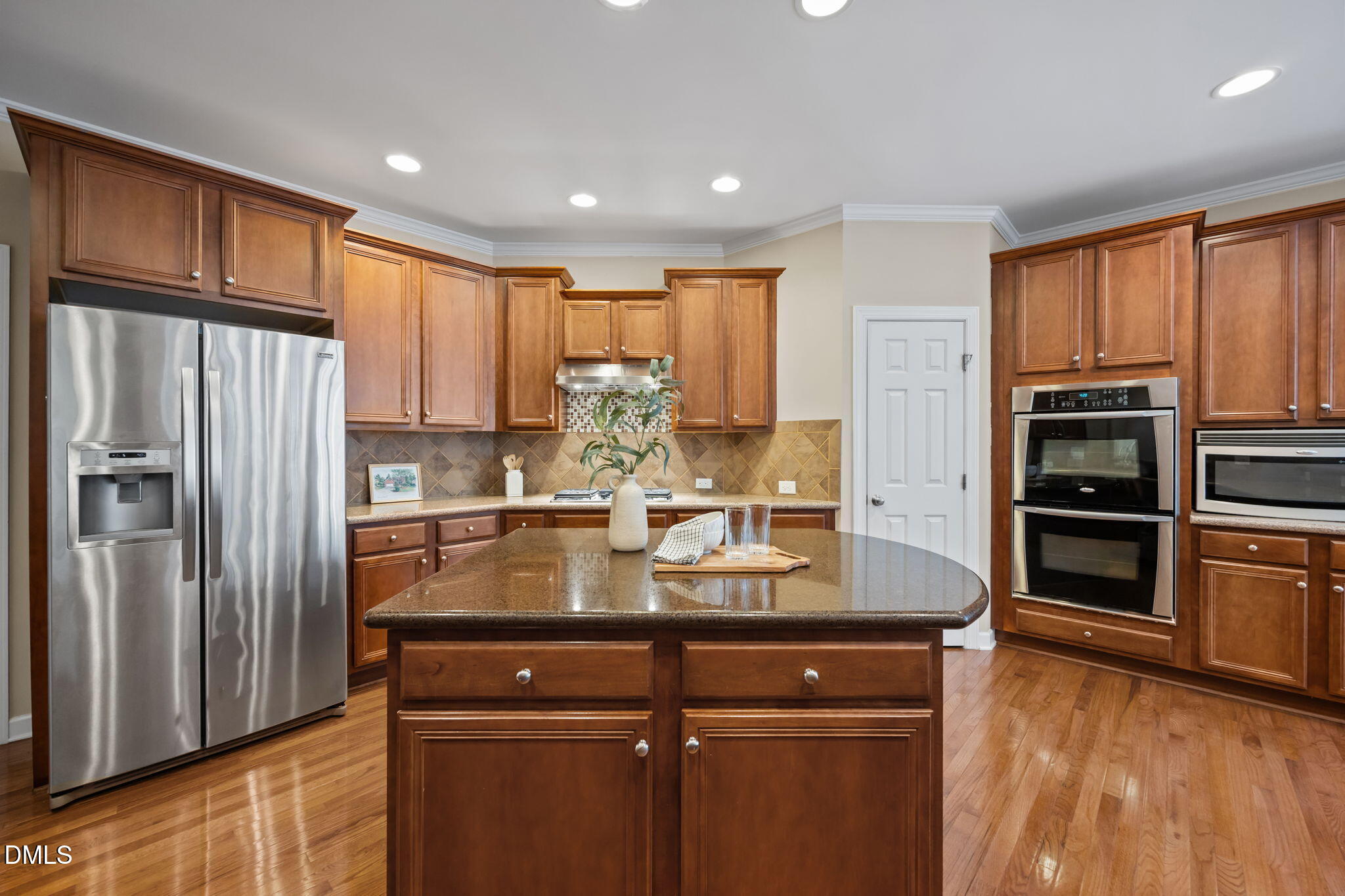 5309 Lyon Farm Drive Durham, NC 27713 - Photo 11 of 68 a kitchen with kitchen island granite countertop a refrigerator and cabinets