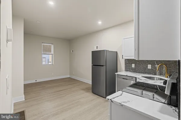 a kitchen with a refrigerator and a stove top oven