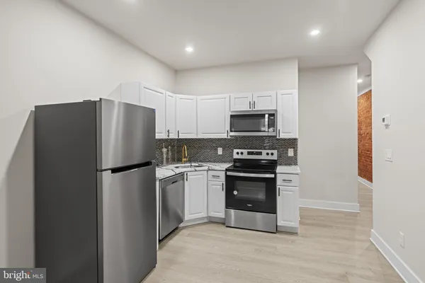 a kitchen with a refrigerator and a stove top oven