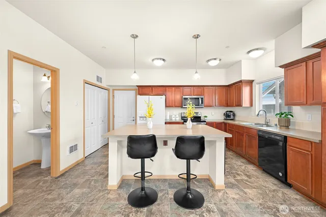 a view of kitchen with stainless steel appliances granite countertop living room and chairs