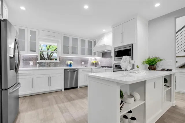 a kitchen with white cabinets and refrigerator