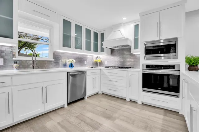 a kitchen with white cabinets stainless steel appliances and sink