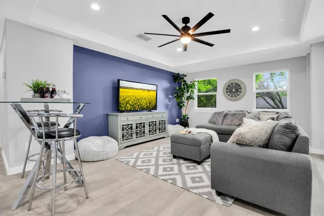 a living room with furniture a window and a flat screen tv