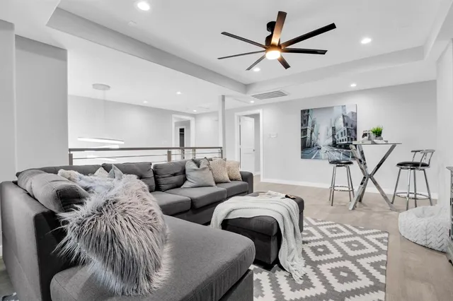 a living room with furniture and a ceiling fan