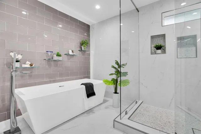a white bath tub sitting in a bathroom and mirror