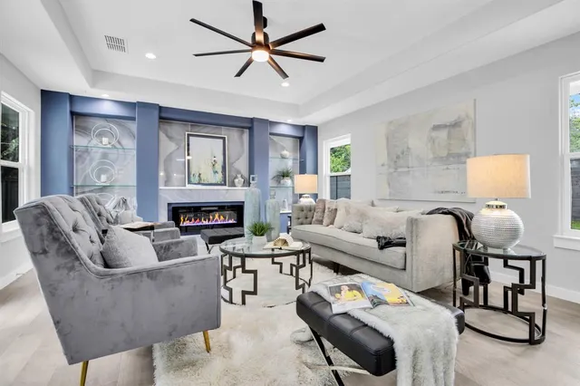 a living room with furniture a fireplace and a chandelier