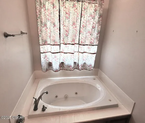 a bathroom with a tub and window