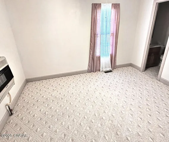 a view of a room with wooden floor and a window