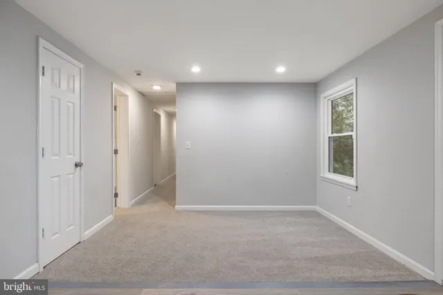 a kitchen with white cabinets and window