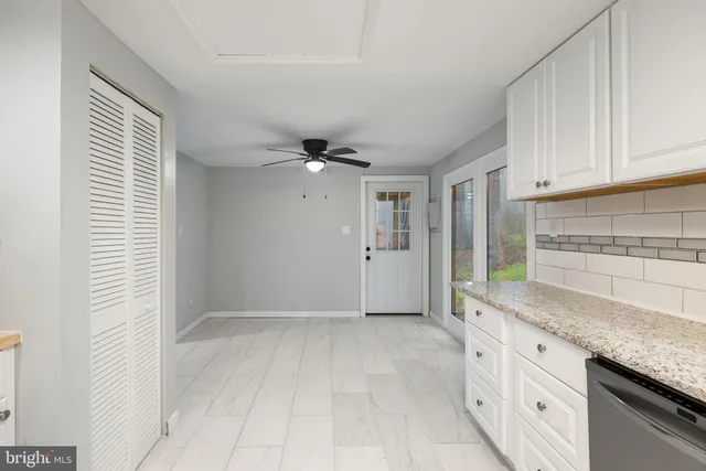 a view of an empty room with closet and a window