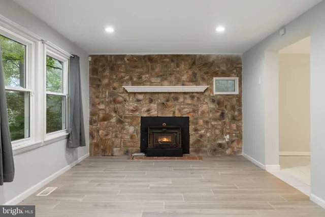 an empty room with fireplace and mirrors