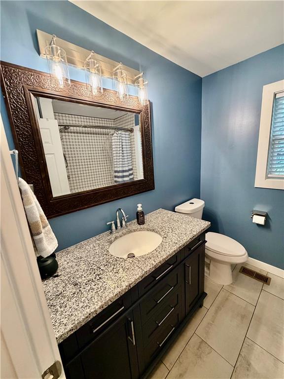 525 Wildcat Bridge Road Royston, GA 30662 - Photo 17 of 26 a bathroom with a granite countertop toilet a sink and a mirror