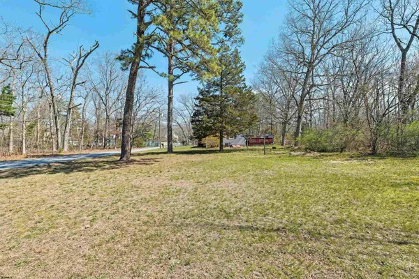 a view of a house with a yard and large trees
