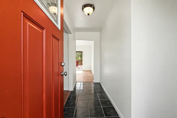 a view of a hallway with wooden floor and a bathroom