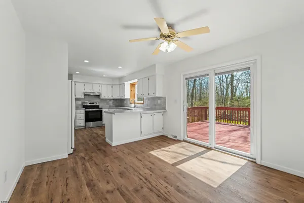 a kitchen with stainless steel appliances granite countertop a stove top oven a sink dishwasher and a refrigerator with wooden floor