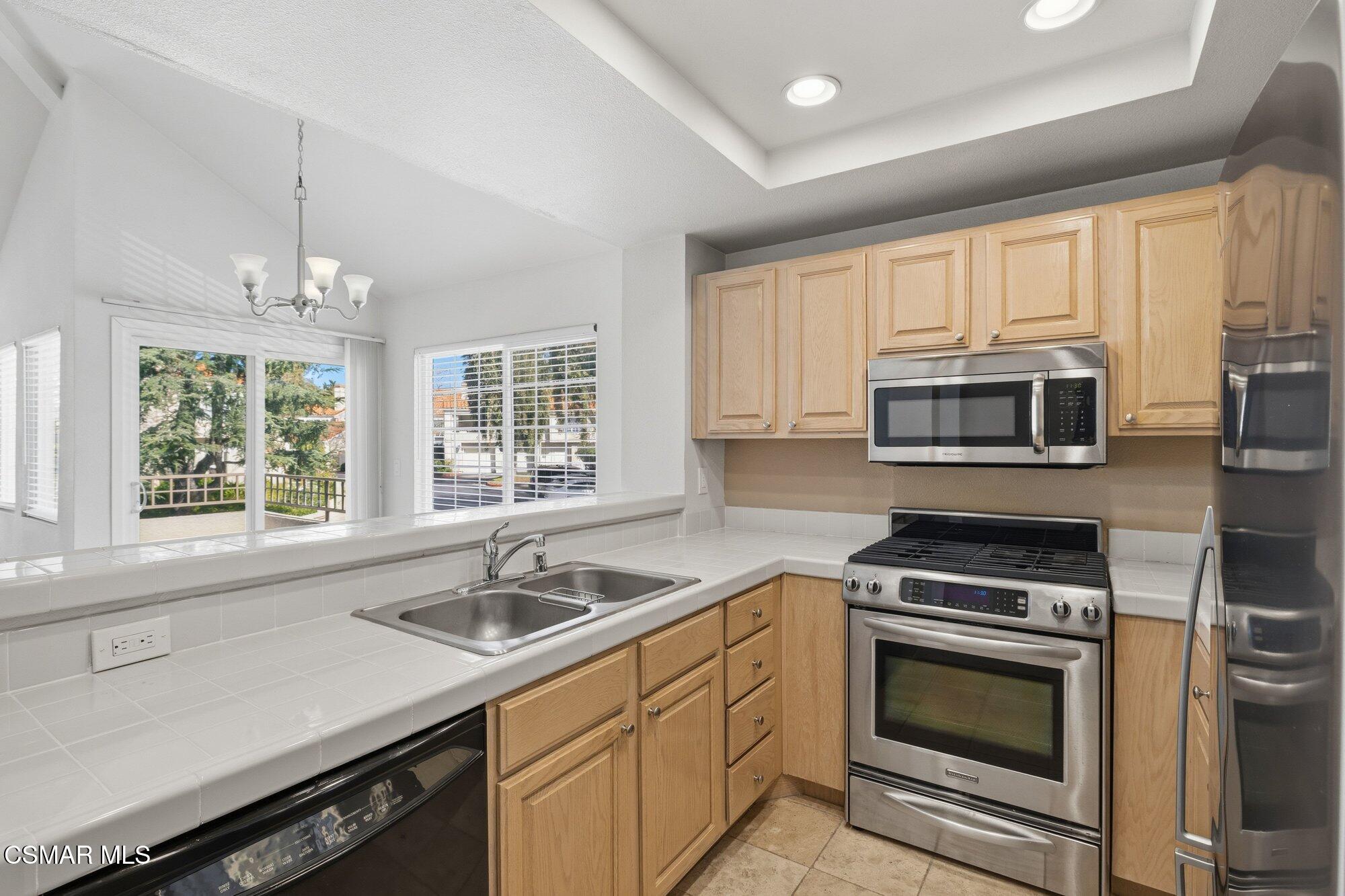 4240 Lost Hills Road, Unit 206 Agoura Hills, CA 91301 - Photo 17 of 28 a kitchen with stainless steel appliances a sink stove and microwave