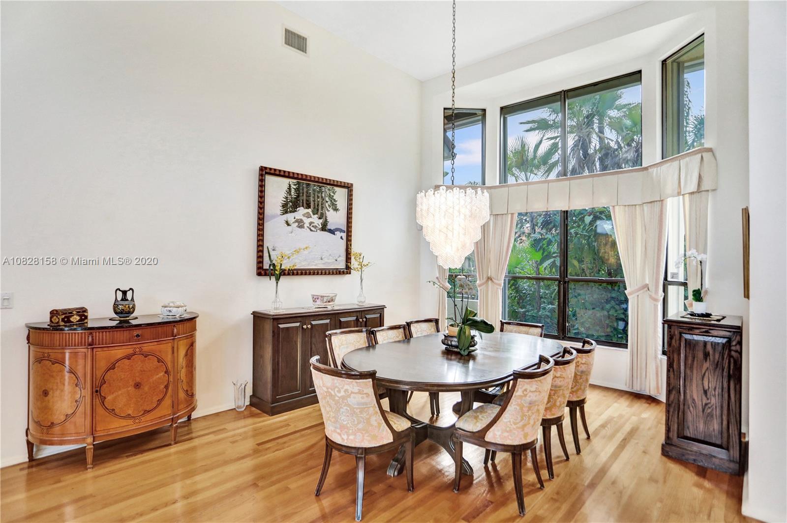 390 Alexandra Circle Weston, FL 33326 - Photo 19 of 71 a dining room with wooden floor a chandelier a glass table and chairs