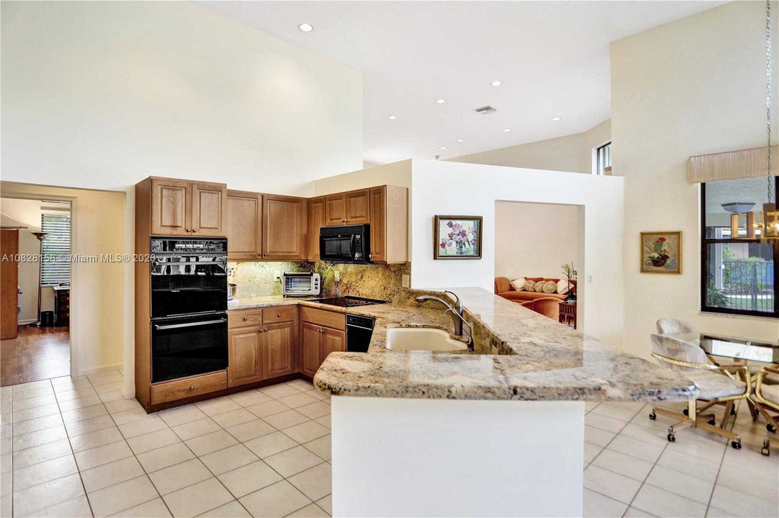 390 Alexandra Circle Weston, FL 33326 - Photo 29 of 71 a kitchen with granite countertop a sink cabinets and stainless steel appliances