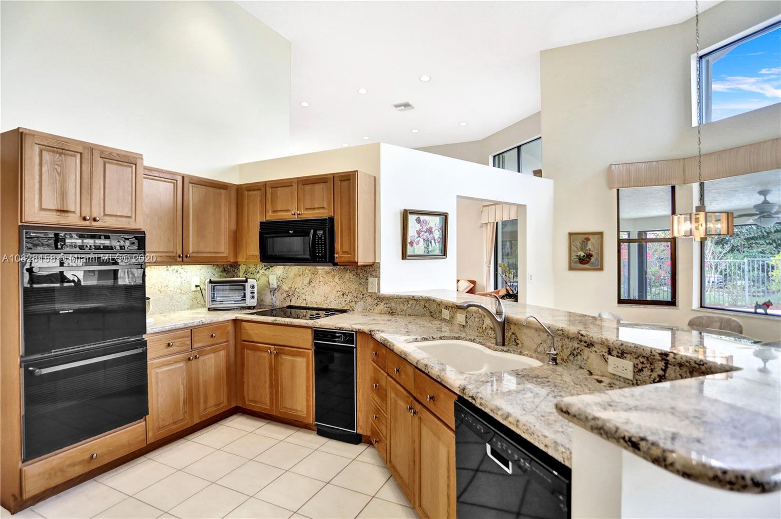 390 Alexandra Circle Weston, FL 33326 - Photo 32 of 71 a kitchen with granite countertop stainless steel appliances a sink stove top oven and cabinets