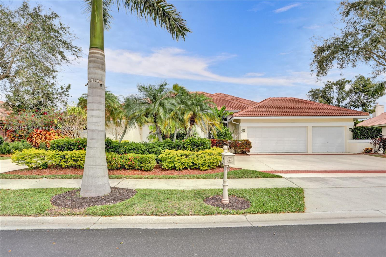 390 Alexandra Circle Weston, FL 33326 - Photo 5 of 71 a front view of a house with a yard and palm trees