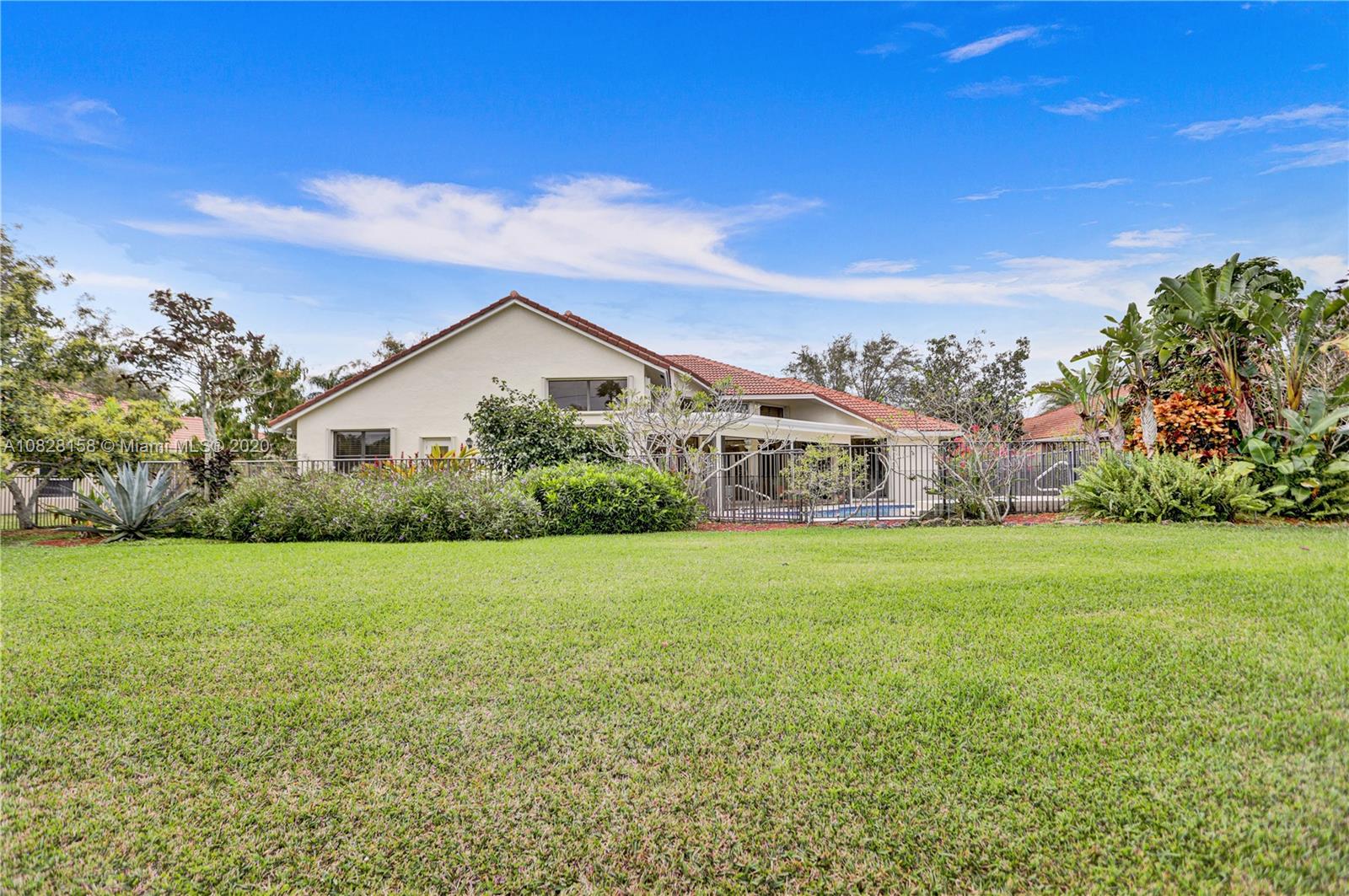390 Alexandra Circle Weston, FL 33326 - Photo 52 of 71 a front view of house with yard and trees in the background