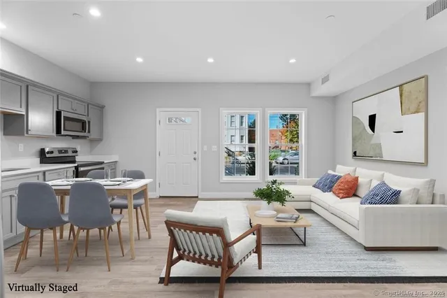 a living room with furniture and a wooden floor