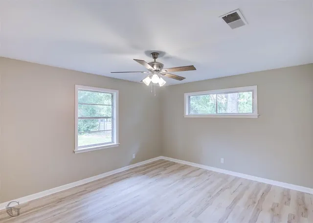 a view of a room with wooden floor and windows