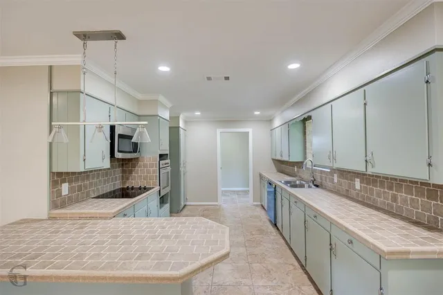 a large kitchen with kitchen island a sink stainless steel appliances and cabinets