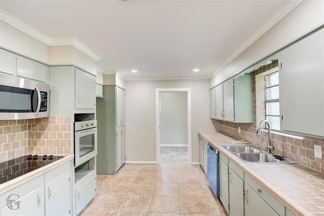 a large kitchen with a sink and stainless steel appliances