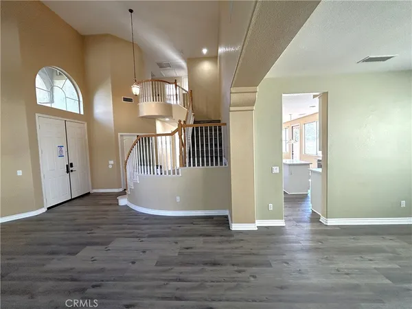 a view of a hallway with wooden floor and windows