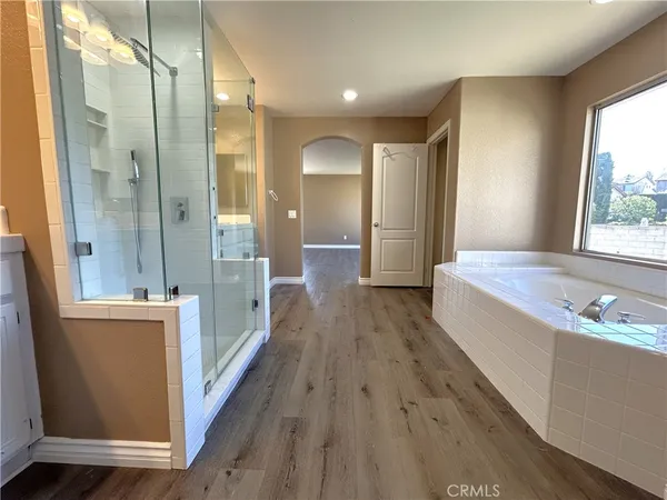a view of a bathroom with tub mirror and window