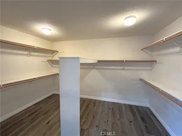 a view of walk in closet with wooden floor