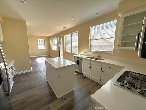 a kitchen with a sink stove and wooden floor