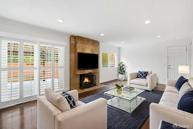 a living room with furniture a flat screen tv and a fireplace