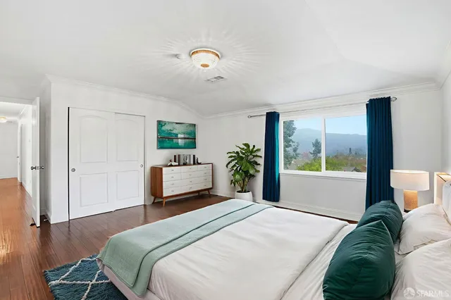 a bedroom with a bed and a large window