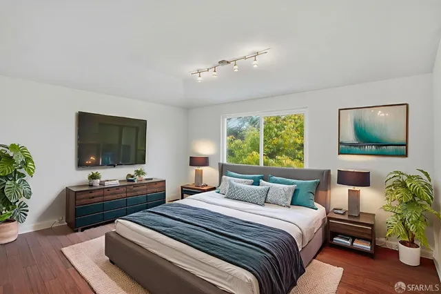 a bedroom with a bed and a flat screen tv