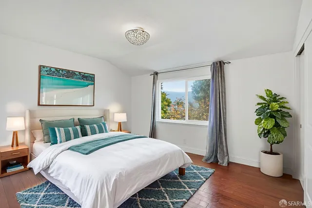 a bedroom with a bed and a potted plant