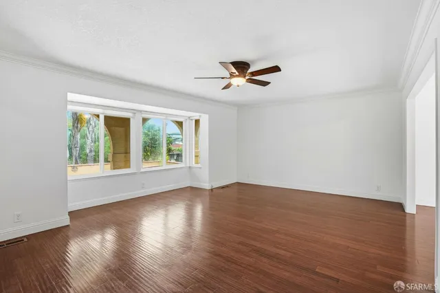 a view of room with hardwood floor and a ceiling fan