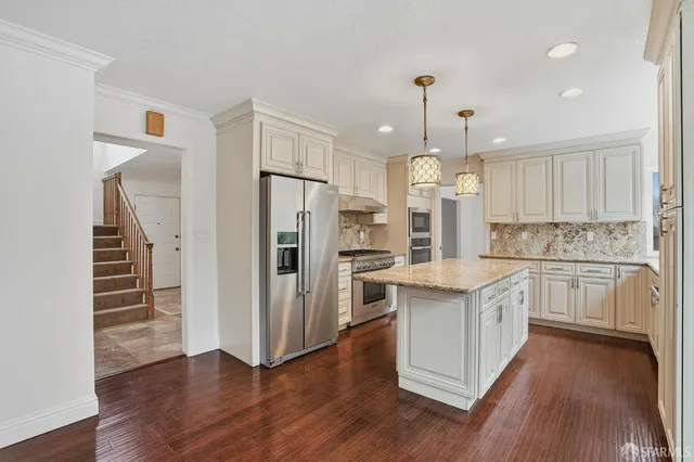 a kitchen with refrigerator a sink and wooden floor