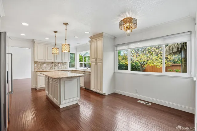 a kitchen with kitchen island white cabinets and refrigerator
