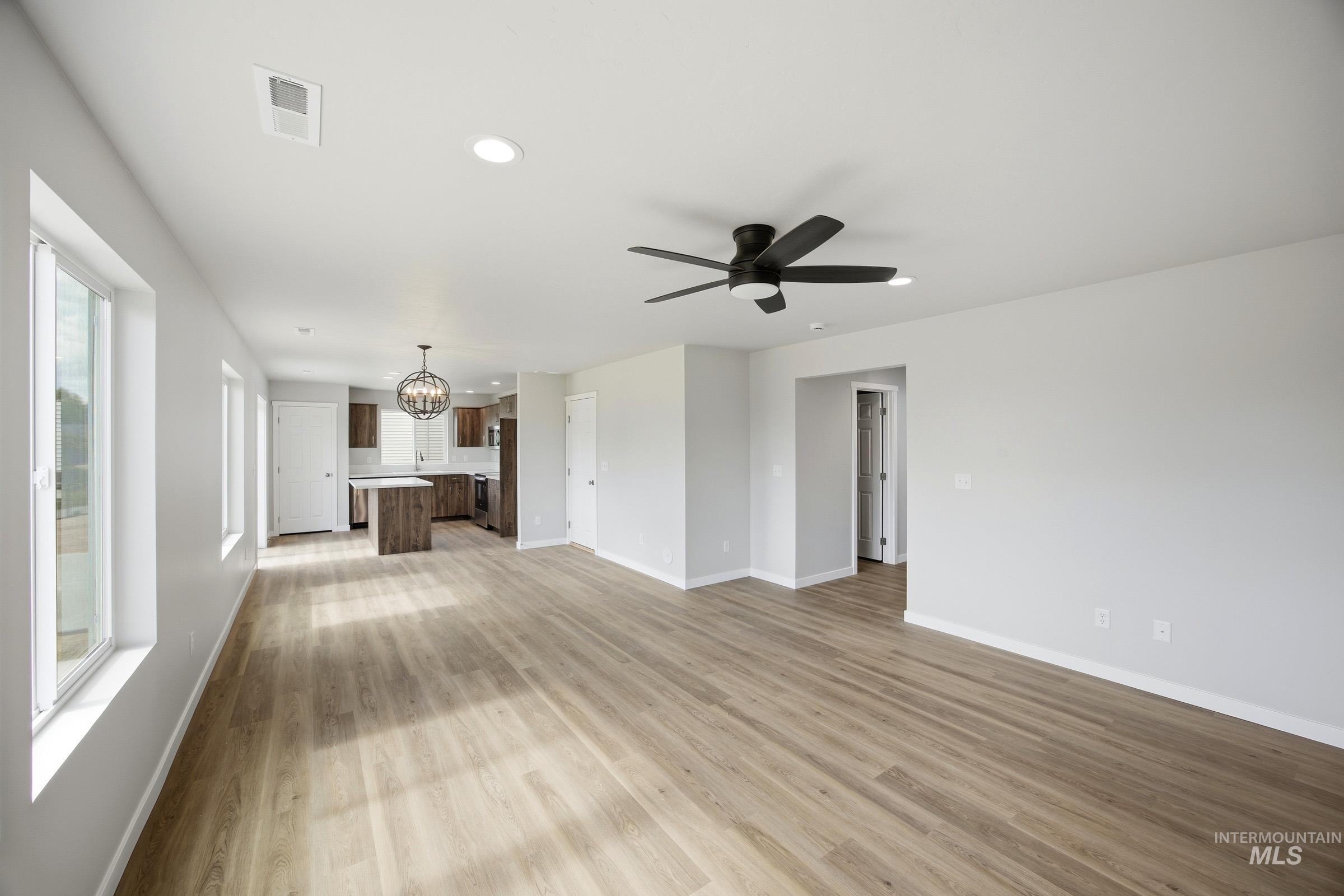 14044 Shiny Spruce Street Caldwell, ID 83607 - Photo 9 of 24 Open-concept living area featuring wood-finish flooring, recessed lighting, multiple windows, and a black ceiling fan