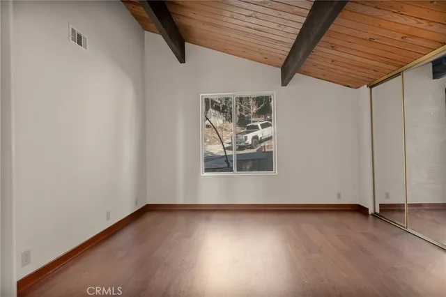 an empty room with wooden floor and window