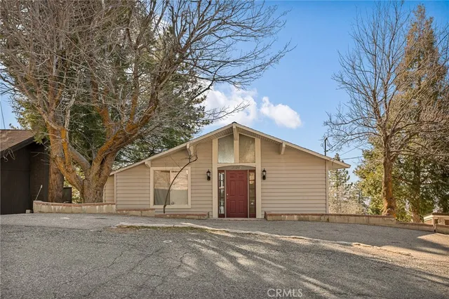 a view of a house with a yard and large tree