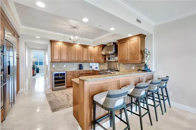 a kitchen with kitchen island granite countertop wooden cabinets and a refrigerator