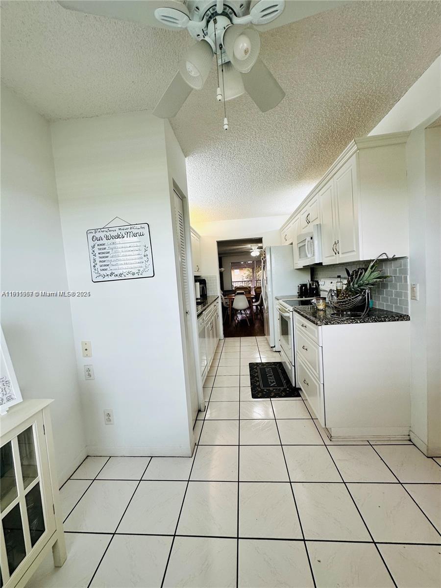 1400 Southwest 124th Terrace, Unit 402Q Pembroke Pines, FL 33027 - Photo 6 of 20 a kitchen with a stove a refrigerator and cabinets