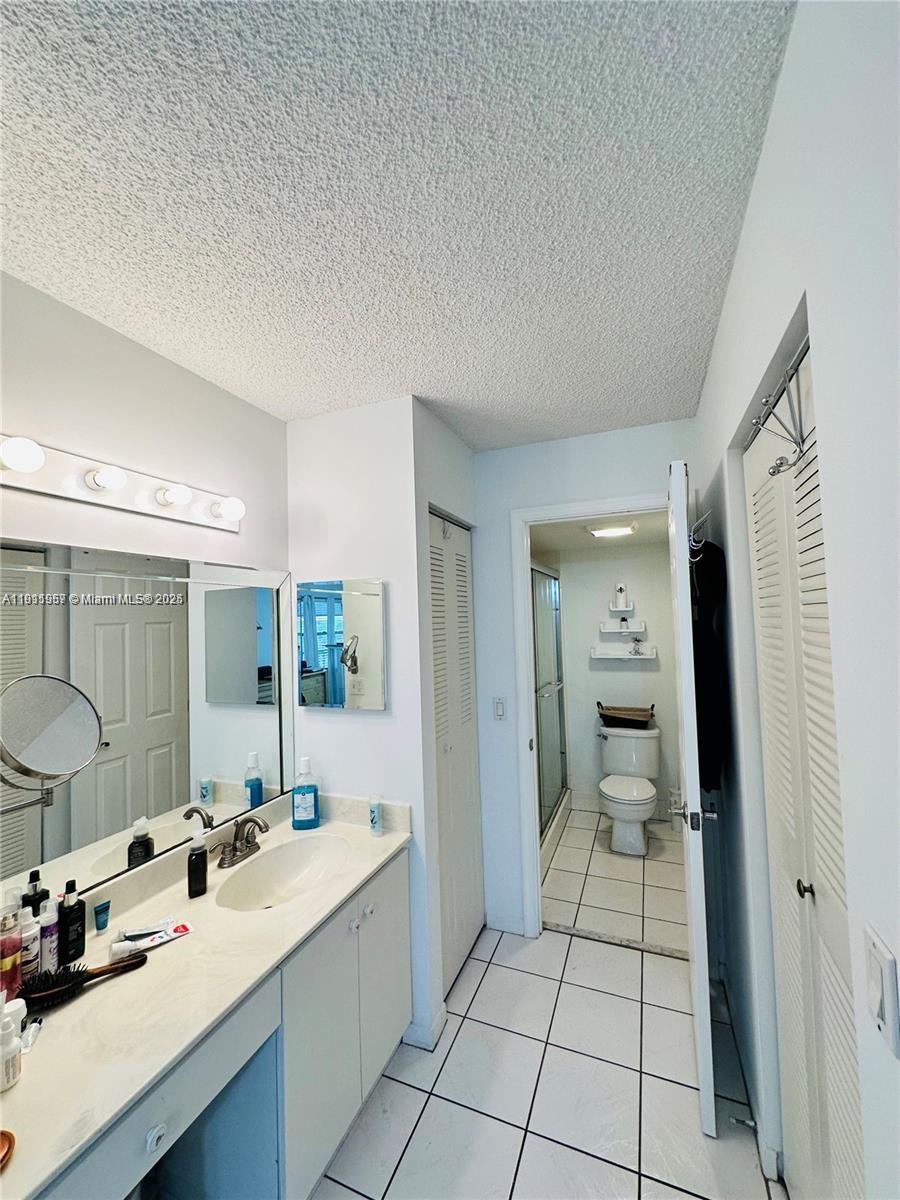 1400 Southwest 124th Terrace, Unit 402Q Pembroke Pines, FL 33027 - Photo 8 of 20 a bathroom with a sink mirror and a shower